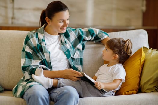 Single Parent. Young Mom And Her Toddler Daughter Reading Book At Home,