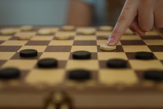 close-up view of a hand of elderly woman playing chess.