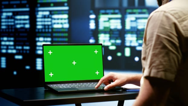 Programmer using green screen laptop