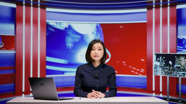 Asian presenter hosting news segment