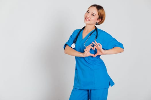woman doctor in medical suit shows heart