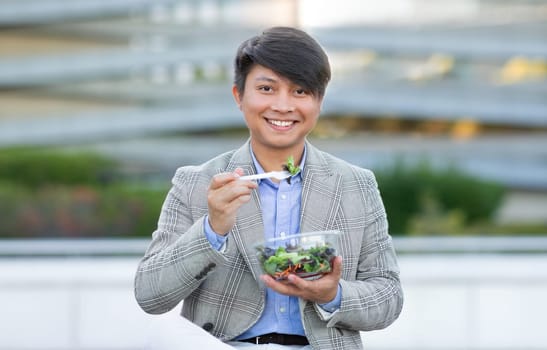 Korean entrepreneur man enjoys salad amidst urban city area