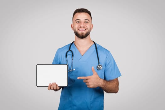 Male nurse pointing at blank tablet screen