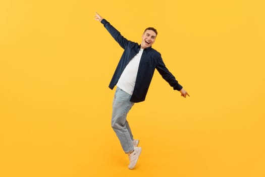Positive young guy posing on yellow background