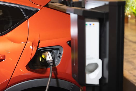 An Emission-Free Future: The Vibrant Orange Electric Car Charging at the Station