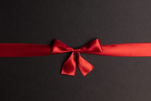Red gift bow on black