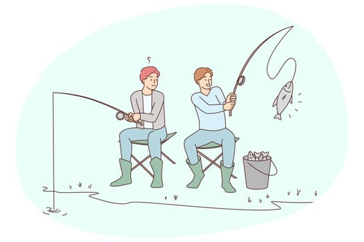 Men sitting on bank fishing