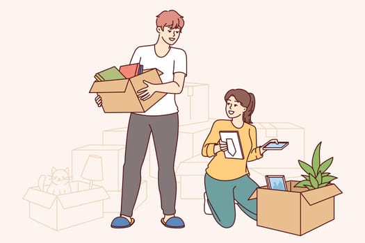 Happy couple moves into new apartment, unpacking boxes and rejoicing at improved home conditions