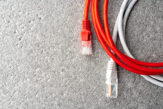 Colored network cable patch-cord on gray textured background