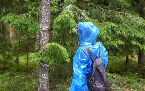 Woman in blue protective polyethylene raincoat agains