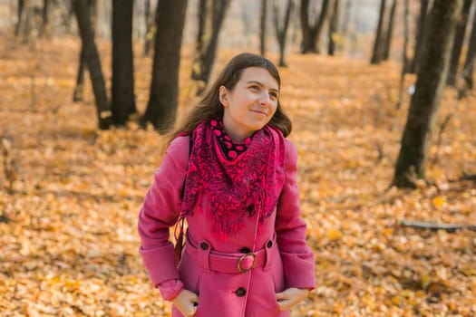 Beautiful happy smiling girl with long hair wearing black hat and pink jacket posing in autumn park. Outdoor portrait day light. Autumn mood concept. Generation Z and gen z youth. Copy empty space for text.