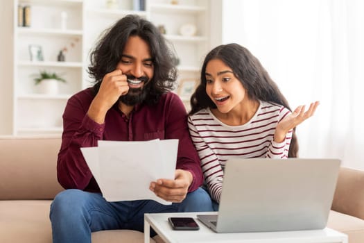 Smiling Millennial Indian Couple Discussing Total Amount Of Their Spends
