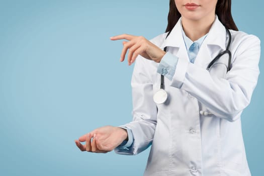 Female medic in white coat holds invisible object