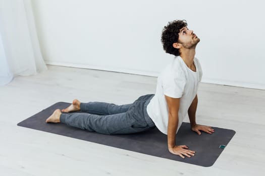 a man does gymnastics warm-up exercises yoga