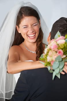 Laughing, bride and groom in embrace at wedding with fun, love and commitment at reception. Smile, face of woman and man hugging at marriage celebration with happiness, loyalty and future together.