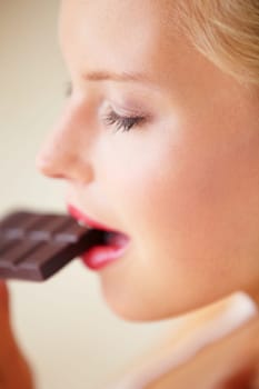Relax woman face, eating and bite chocolate bar, tasty cocoa snack or unhealthy junk food for wellness, stress relief or craving. Head profile, antioxidant product benefits and girl enjoy cacao slab