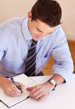 Businessman at desk with pen, notebook and smile, thinking and market research plan at startup. Office, notes and man writing schedule, agenda or to do list in book at agency with ideas for project.