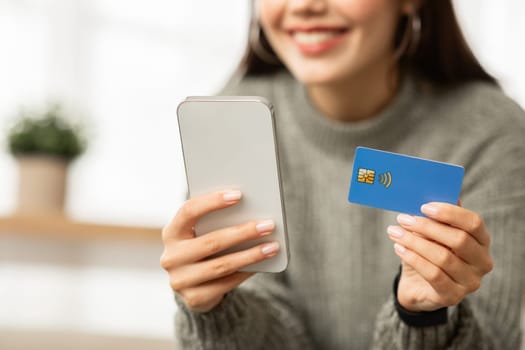 Cropped of young woman holding phone and credit card