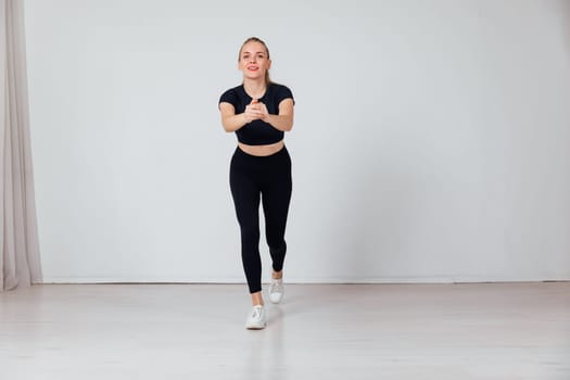 a woman doing exercises in a bright room exercises warm-up