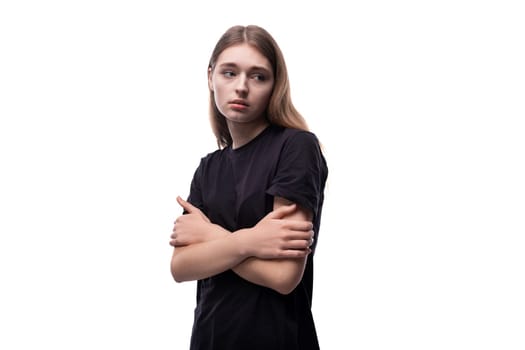 Portrait of a teenage girl with model appearance in a black T-shirt posing for the camera