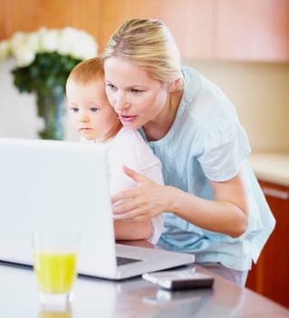 Woman, baby and laptop for showing in home for learning, playing on streaming online. Mother, little boy or love in bond for growth, development or milestone with skills for technology in kitchen