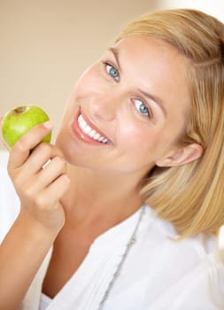 Happy woman, holding and apple in portrait for health, nutrition or wellness. Female person, smile and fruit in hand for wellbeing, vitamin or fibre with choice for natural, fresh or organic diet