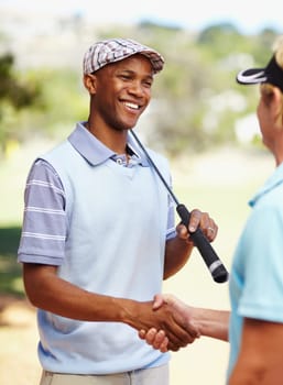 Sports, golf and athletes shaking hands on a field for competition, tournament or event. Smile, agreement and professional happy men golfers with handshake for welcome on an outdoor grass course.