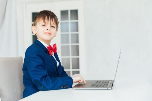 Business boy in jacket sitting at laptop
