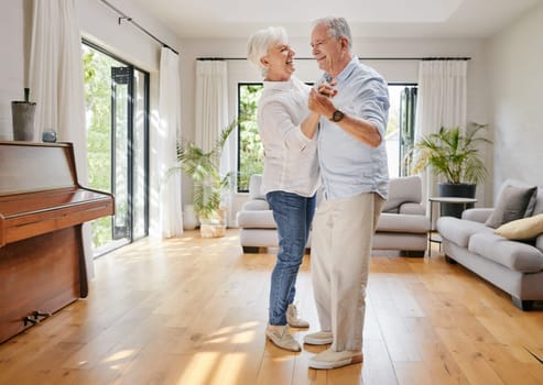 Love, dance and a senior couple in the living room of their home together for retirement bonding. Smile, trust or holding hands with an elderly man and woman moving in their apartment for romance