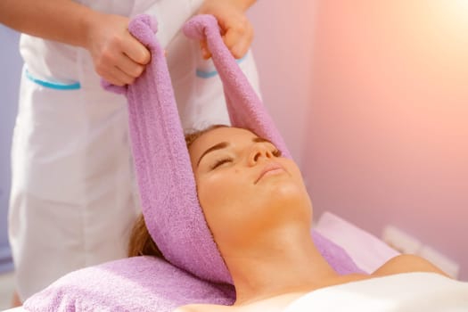 Relaxing massage. European woman getting head massage in spa salon, side view