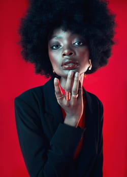 Black woman, portrait and afro, hair and beauty with makeup and shine isolated on red background. Hairstyle, haircare and texture with growth, face skin glow and confident African model in a studio