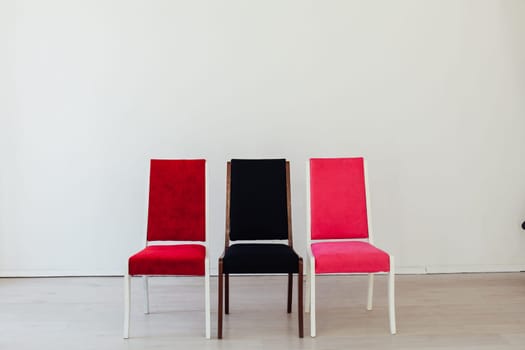 three chairs stand in an empty white room