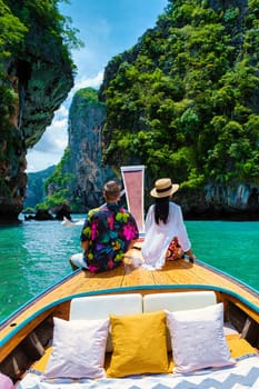 Luxury Longtail boat in Krabi Thailand, couple man and woman on a trip at the tropical island 4 Island trip in Krabi Thailand. Asian woman and European man mid age on vacation in Thailand