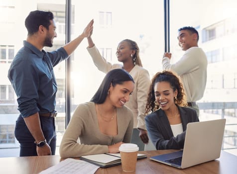 People, high five and success in office with teamwork, collaboration and support for work in startup. Group, celebration and achievement of goals or kpi challenge in workplace and employees on laptop