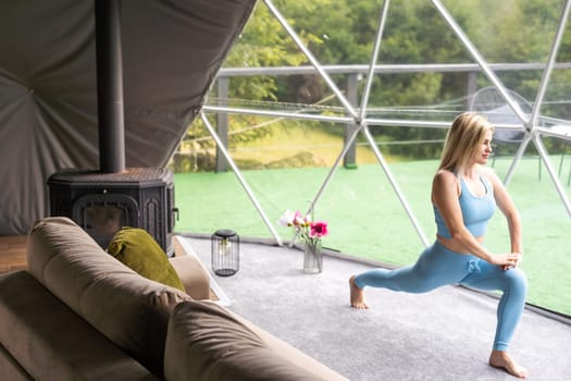 Sporty woman doing exercise in a geo dome glamping tent