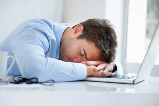 Businessman, laptop and sleeping on office desk in burnout, stress or fatigue from pressure or overworked. Tired man or employee asleep on table with computer in mental health or anxiety at workplace