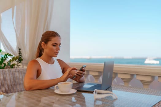 Woman coffee cafe laptop sea. Modern businessman in white uniform working on laptop in coffee shop. Woman sitting at a coffee shop with mobile phone drinking coffee.