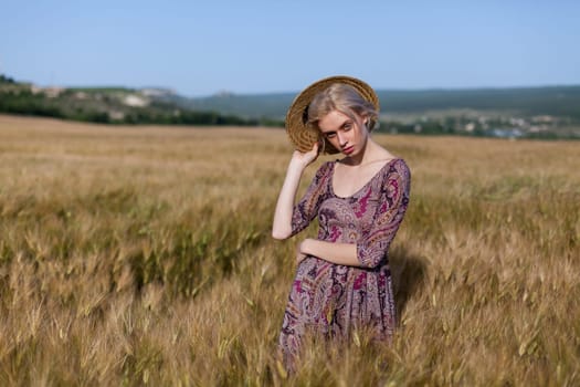 Woman blonde farmer on field of ripe wheat