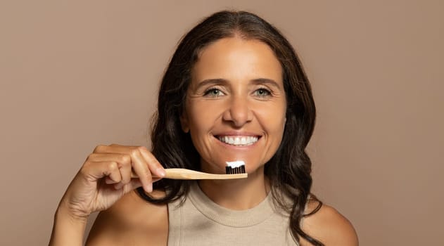 Cheerful caucasian senior woman brushing teeth with toothbrush, enjoy oral care