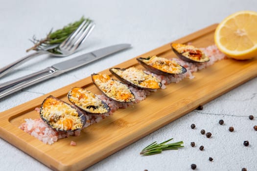 oysters scallops with red sea salt and citric acid on a wooden tray side view