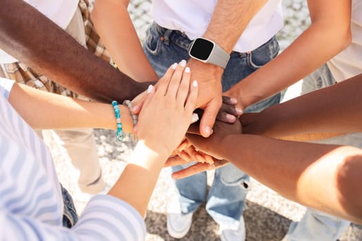 Top view of stacking hands, cropped. International friendship concept, multicultural people representing peace and unity against racism. Integration between diversity. Friends going vacation together
