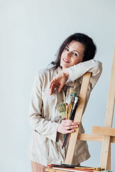 A woman artist at an easel in a hodozhestvennaya studio