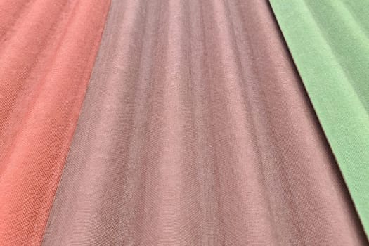 Close up on three sheets of ondulin of different colors. Modern cheap roofing material
