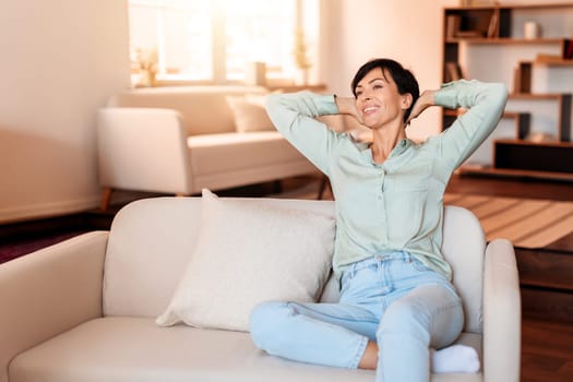 lady enjoying quiet pause comfortably leaning back on sofa indoors