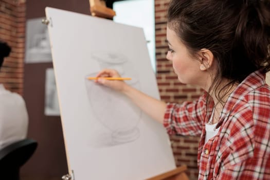 Woman sketching on canvas using pencil