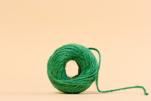 Skein of green thread on a beige background