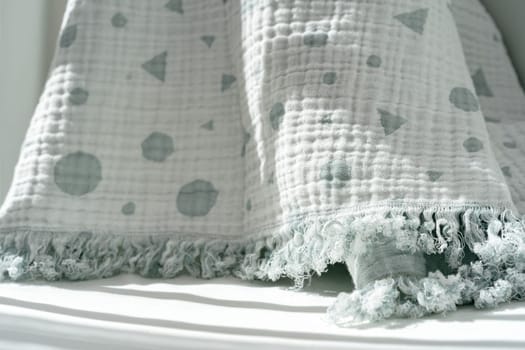 Soft cotton blanket hanging on baby's bed