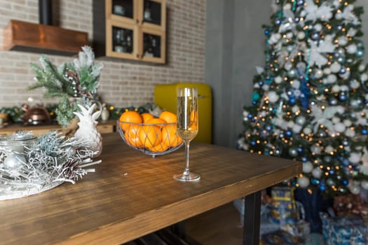 new year's still life, 2 glasses of champagne, tangerines on the table on the background of the Christmas tree.Christmas and new year dietary sweetness