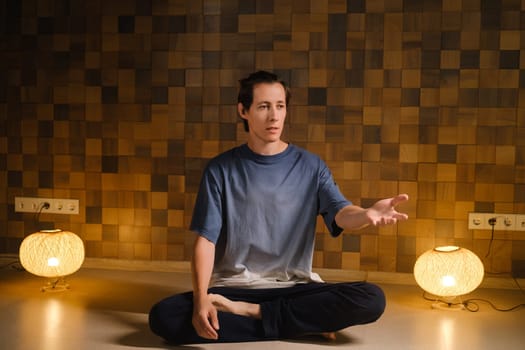 a man in a sports uniform does yoga in a fitness room. the concept of a healthy lifestyle