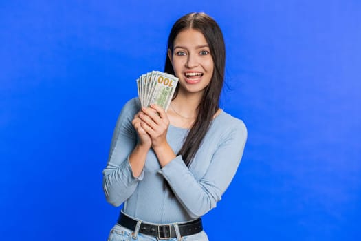 Rich happy woman winner waving money dollar cash like a fan, big income wealth success business